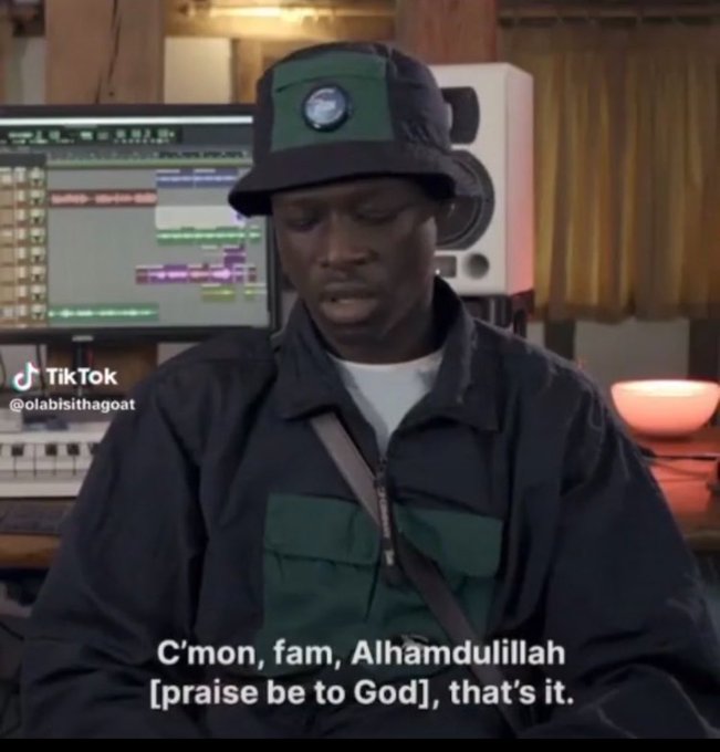 A man in a green bucket hat and jacket sits in a music studio with text overlay reading 'C'mon, fam, Alhamdulillah [praise be to God], that's it.' and a TikTok watermark @olabisithagoat.
