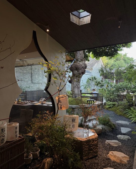 A serene tea garden setting with a lantern, stone path, and Chinese characters including "點心府" and "朝月" on ceramic jars, contrasted against the post's message about holding DOGE and Bitcoin without anxiety due to hidden costs. The tranquil, nature-filled scene visually reinforces the idea of patient, long-term holding as the post advises against anxiety over crypto investments.