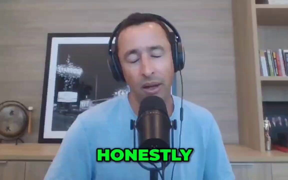 The image features a man wearing headphones, standing behind a microphone as he sings into it. In the background, there are various books on shelves, suggesting that the setting may be a library or a room with ample book storage. At the top of the image, the phrase "IS BITCOIN TO $1 MILLION INEVITABLE? MIKE ALFRED SAYS THERE'S NO CHANCE" is written. The microphone and headphones are positioned for him to be clearly visible in his performance.