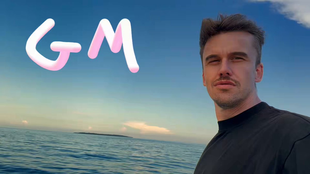 The image features a man standing next to an ocean, with his face turned towards the camera. He appears to be posing for a photo or video. The background of the image shows a beautiful blue sky above the water, creating a serene atmosphere. In the bottom right corner of the image, there is text that reads "GM web4 i bring Solana everywhere". This text seems to be related to the man's pose and the ocean setting, possibly indicating his interest in or connection to the Solana cryptocurrency.