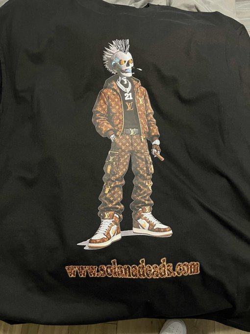 A black t-shirt featuring a skeleton graphic wearing Louis Vuitton patterned clothing and sneakers, with 'www.solanadeads.com' printed below.