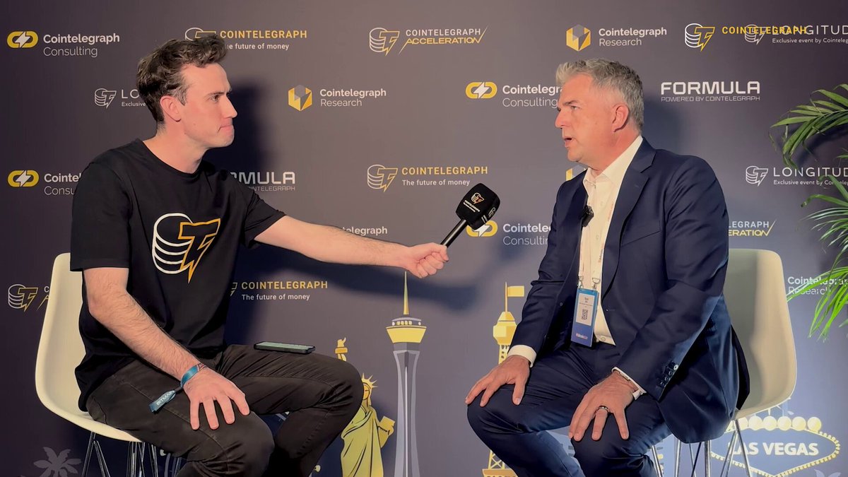The image shows two men sitting in chairs facing each other, engaged in conversation. One man appears to be wearing a suit while the other has a tie. They are positioned against a backdrop featuring logos for companies such as Formula 1, Las Vegas Sands, and CoinGecko. The text on the image reads "Most Bitcoin treasurerty companies are trying to replicate Michael Saylor's success but most will fail," attributed to @macrocrunch. This statement suggests that while some companies may attempt to replicate Michael Saylor's success in Bitcoin trading, only those with a key advantage or unique approach will survive and thrive in the market.