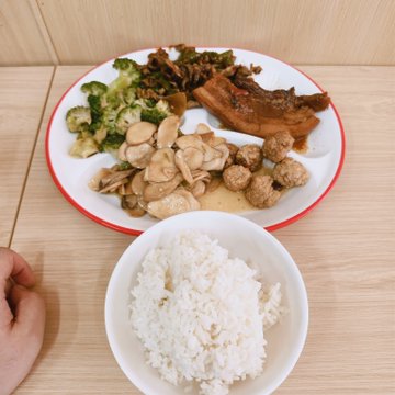 A home-cooked meal featuring braised pork ribs, broccoli, mushrooms, meatballs, stir-fried vegetables, and a bowl of white rice, presented as an affordable $2.36 dish that the poster humorously compares to nearly 9 years of three daily meals funded by their investment losses.