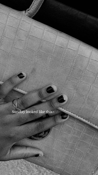 A black-and-white close-up of a manicured hand with dark nail polish resting on a textured crocodile-pattern handbag, with the caption "Sunday looked like this>" overlaid. The polished aesthetic complements the post's "Currently in church how about you?" suggesting a chic, Sunday-best look during a church visit.