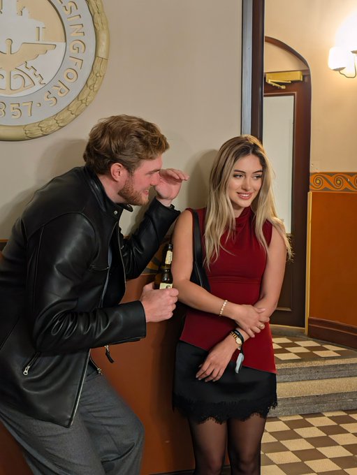 A man in a black leather jacket whispers to a woman in a red top holding a beer bottle, standing in front of a wall emblem reading "KINGFORS...857" and a checkered floor. The playful, conspiratorial pose humorously echoes the caption's tone of sharing insider information about OCEAN's decentralized mining philosophy.