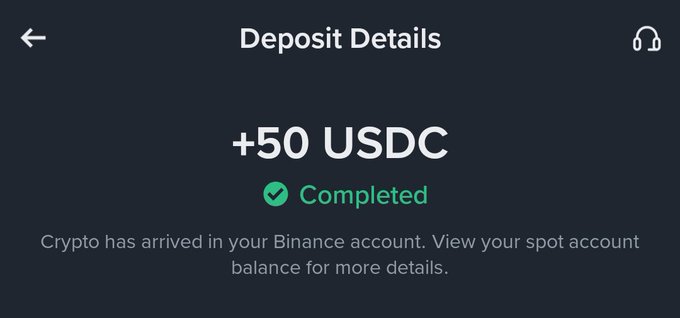 A mobile screen showing a completed deposit of '+50 USDC' on what appears to be a Binance account, with text confirming crypto has arrived in the spot account.