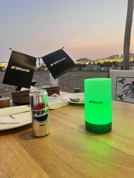 A Bitunix-branded green glow lamp illuminates a waterfront dining table alongside a Pepsi can and Bitunix flags, capturing a luxurious evening moment that mirrors the VIP lifestyle promised by the post's invitation to join Bitunix's exclusive VIP community.