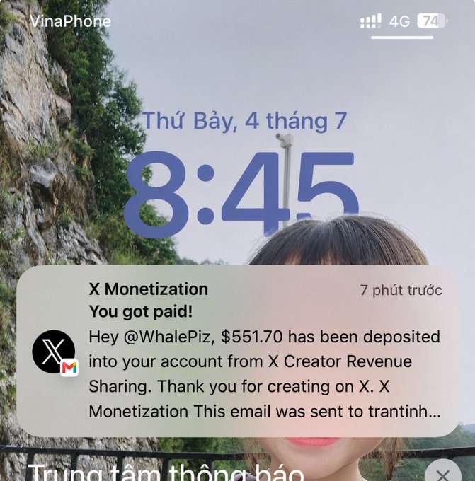 An iPhone lock screen from 'VinaPhone' showing the date 'Thứ Bảy, 4 tháng 7' and time '8:45', with a notification from 'X Monetization' stating 'Hey @WhalePiz, $551.70 has been deposited into your account from X Creator Revenue Sharing.'