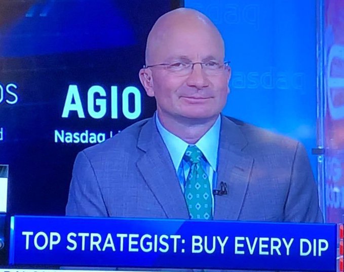 A bald man in a gray suit and teal tie appears on CNBC with AGIO/Nasdaq branding and a chyron reading 'TOP STRATEGIST: BUY EVERY DIP.'