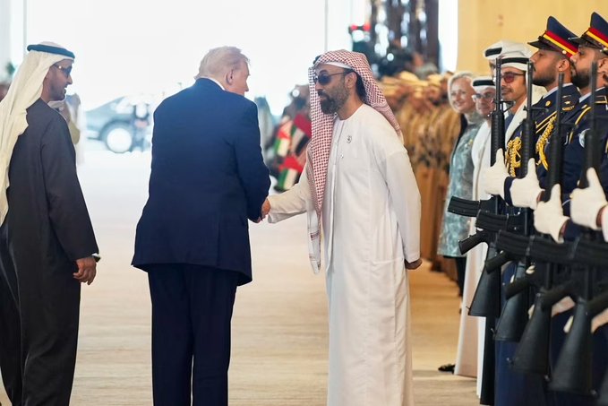 Sheikh Tahnoon bin Zayed, UAE national security adviser, shakes hands with Donald Trump in front of a military honor guard. This meeting highlights his significant stake in the Trump family's new crypto bank, World Liberty.