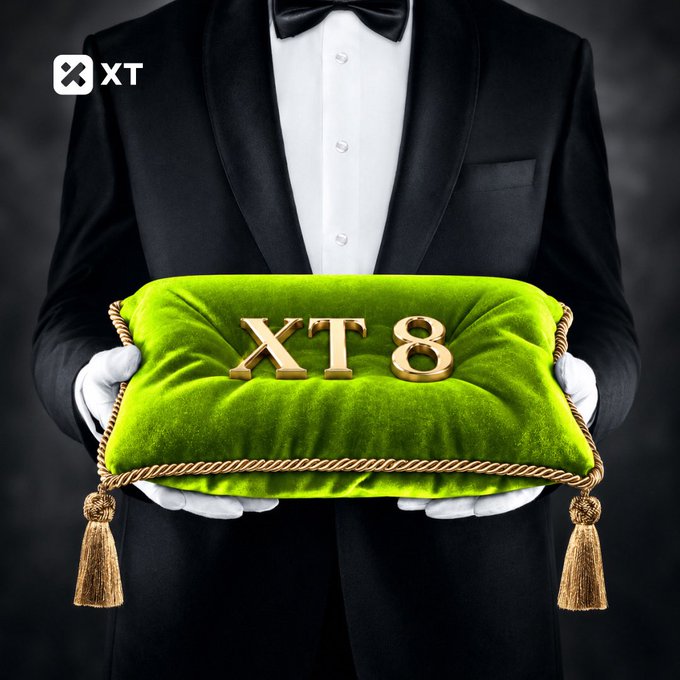 A butler in a tuxedo holding a green velvet pillow with gold tassels displaying 'XT 8' and the XT.com logo in the corner.