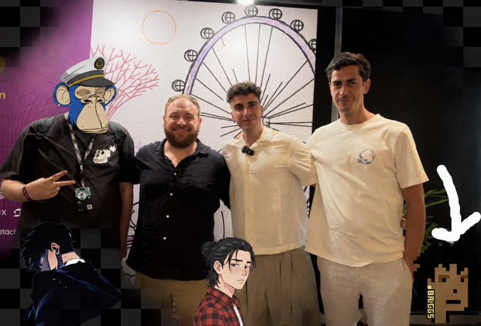 Four people pose together at what appears to be an event, with one person's face obscured by a Bored Ape NFT image, and anime-style character stickers added to the photo.