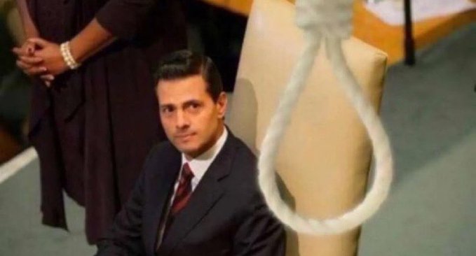 A man in a suit with a red tie sits looking at a hangman's noose dangling in front of him in what appears to be an execution scene.