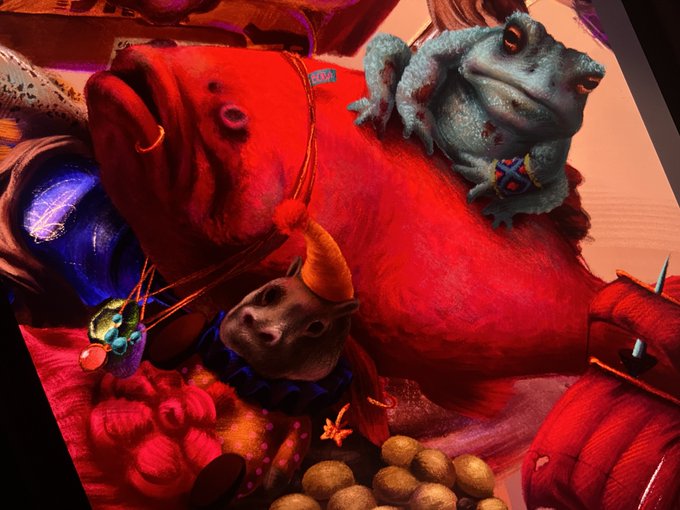 A vibrant 3D illustration features a small gray frog perched atop a large red creature, accompanied by a small rat-like figure wearing a party hat.