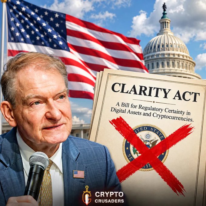 A composite image showing an older man in a suit with an American flag pin speaking into a microphone, alongside a document titled 'CLARITY ACT: A Bill for Regulatory Certainty in Digital Assets and Cryptocurrencies' that has a large red 'X' drawn over its seal, with a 'Crypto Crusaders' logo at the bottom.