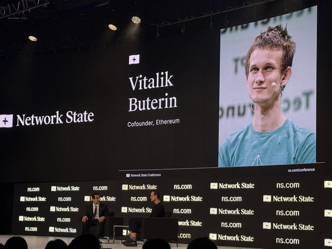 Vitalik Buterin, cofounder of Ethereum, appears on a large screen at the Network State Conference (ns.com) during an on-stage interview.