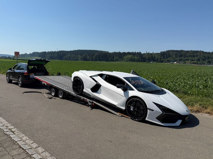 The image shows a white Lamborghini sports car being transported on a flatbed trailer, driving down a road next to a grassy field with trees in the background. The car appears to be in good condition, as it has been recently purchased by someone who is now selling it for more money than they paid for it.

The post about the Lamborghini sale seems to be related to the image, possibly discussing the details of the sale or providing information on the car's history and value. The post might also be promoting a website or service that specializes in buying and selling luxury vehicles like Lamborghinis.