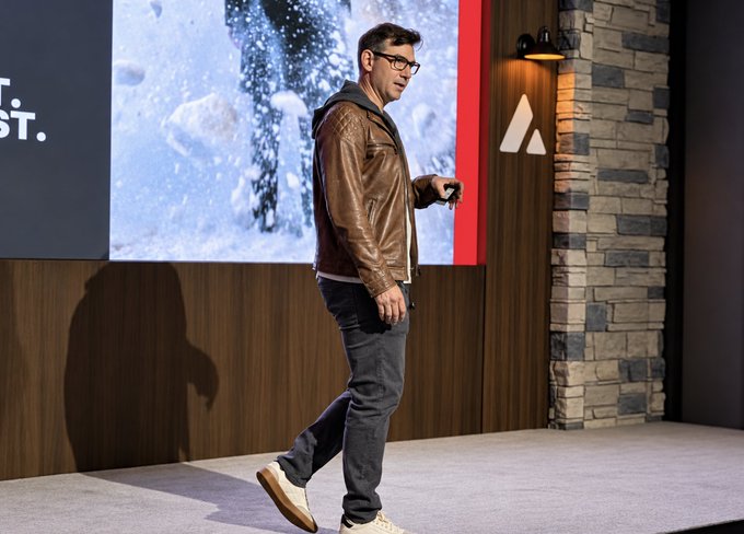 The CIO of FrostLedger delivers a keynote at the Avalanche Summit, presenting the Foundation's research and plans for the AVAX token, standing on stage before a large screen displaying an icy backdrop and the Avalanche logo.