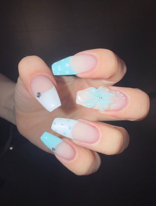 A hand displays long, coffin-shaped acrylic nails featuring a mint green and white color palette with polka dot patterns and a 3D flower accent, perfectly matching the "Mintcore" aesthetic mentioned in the caption.