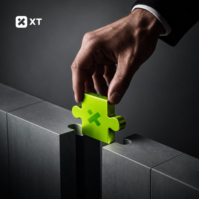 A hand in a suit sleeve places a glowing green puzzle piece into a dark gray structure, with an 'XT' logo in the upper left corner.