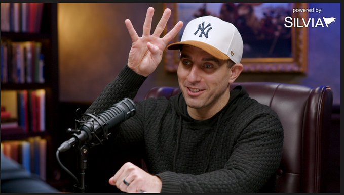 A man in a New York Yankees cap and black hoodie gestures with five fingers raised while speaking into a microphone during a podcast, with a "powered by: SILVIA" logo visible in the corner. The image likely relates to the "IYKYK" caption as a teaser for niche insider knowledge being shared on the show, with the SILVIA branding suggesting the platform or sponsor behind the content.