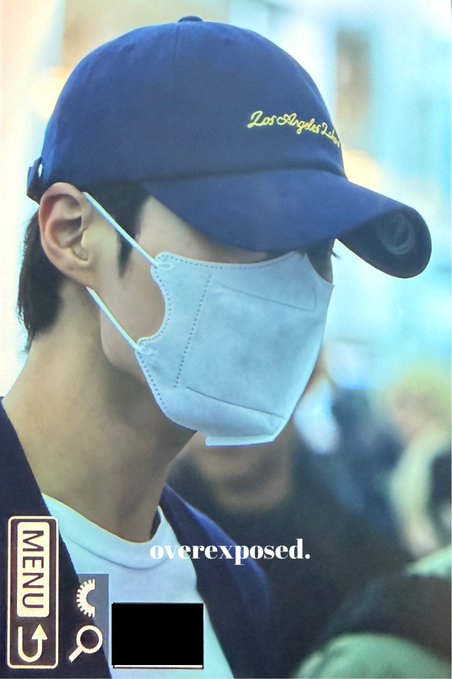 A close-up profile shot of a young man wearing a navy 'Los Angeles Dodgers' cap and a light-colored face mask, with 'overexposed.' text overlaid and a camera menu interface visible on the left.