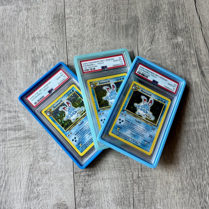 Three PSA 10 graded 2000 Pokemon Neo Genesis Azumarill holographic cards displayed in protective slabs on a wooden surface.