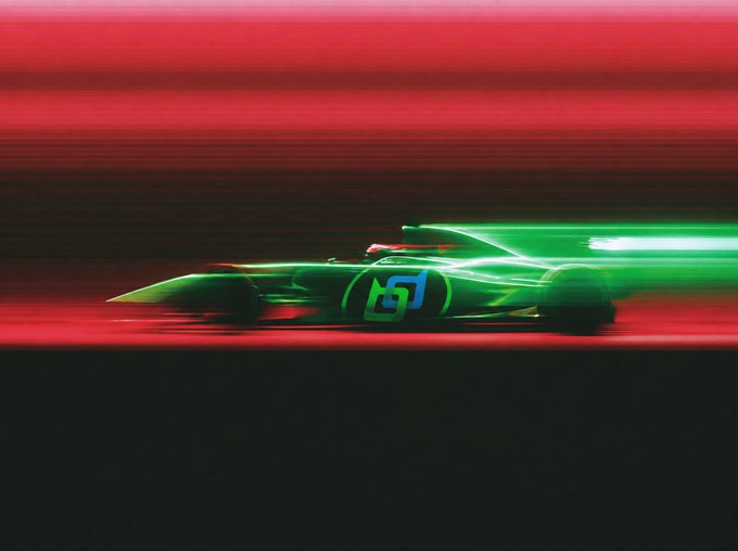 A green racing car with the number 5 races along a track, creating motion blur streaks against a dark red background.