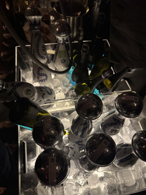 An overhead view shows several wine bottles chilling in ice-filled containers, with white ceramic bottles featuring blue floral designs mixed among green glass ones.

The image of wine bottles on ice complements the post's casual tone, suggesting the "Vietnamese exchange" involves swapping wine selections rather than financial trading, with the chilling ice hinting at a relaxed social gathering.