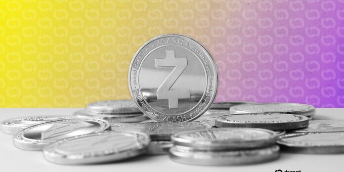 A pile of silver 'Z CASH' cryptocurrency coins rests on a white surface against a yellow and purple gradient background with faint coin patterns.
