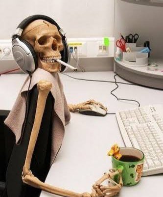 A skeleton figurine wearing headphones and holding a cigarette sits at a desk in front of a keyboard and mug, appearing to use a computer.