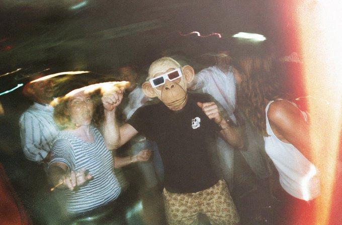 The image shows a group of people at a party, with one person wearing a monkey mask and sunglasses. They are dancing together, creating an atmosphere of fun and excitement. The caption "GM party is on bored ape yacht club" suggests that this gathering might be related to a themed event or party where the attendees are dressed up in costumes like the monkey mask.