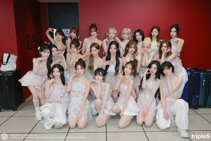 A group photo of the K-pop group tripleS, with a watermark reading 'tripleS' and copyright text for 'Modhaus', taken backstage, likely from their 'Are You Alive?' tour.
