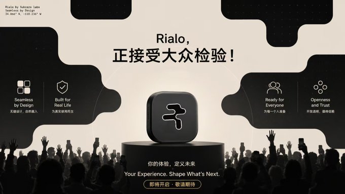 The image features a large crowd of people gathered around a stage, with some individuals holding up their phones. The main focus of the scene is an advertisement for Rialo, which includes a square logo prominently displayed at the center of the image. The text on the image reads "Rialo! Your experience. Shape What's next." This suggests that the crowd has gathered to learn more about or participate in the product being advertised by Rialo.