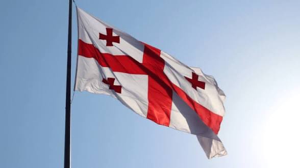 через поля "Стандарт" (Стандарт) is displayed on a white flag with red and blue stripes, fluttering against a clear blue sky.