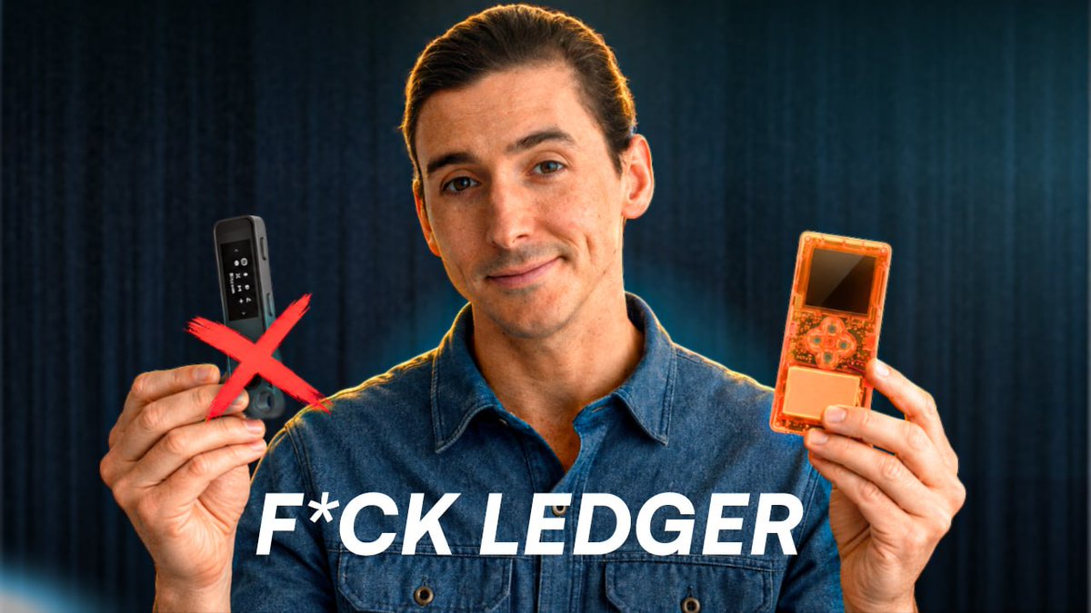 A man in a denim shirt holding a Ledger hardware wallet with a red X over it in one hand and another cryptocurrency wallet device in the other, with the text 'F*CK LEDGER' displayed at the bottom.