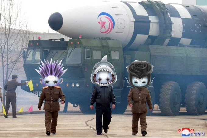 A North Korean military parade scene showing soldiers marching in front of a large missile launcher, with three figures in the foreground whose faces have been replaced with cartoon character images.
