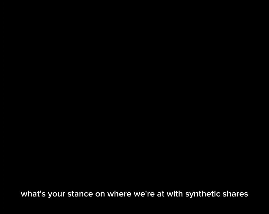 The image shows a black square with white text that reads "Is your stance on where we're at with synthetic shares? Adam Aron". The text is written in all capital letters, making it stand out against the black background of the image.