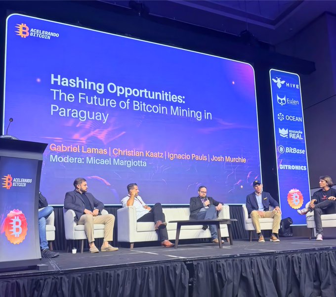 A panel discussion titled "Hashing Opportunities: The Future of Bitcoin Mining in Paraguay" takes place at the "Acelerando Bitcoin" event, featuring speakers Gabriel Lamas, Christian Kaatz, Ignacio Pauls, Josh Murchie, and moderator Micael Margiotta, with HIVE among the sponsoring brands displayed on the screen—aligning with the post's highlight of HIVE's Paraguay Site President contributing to the conversation on the country's BTC mining future.