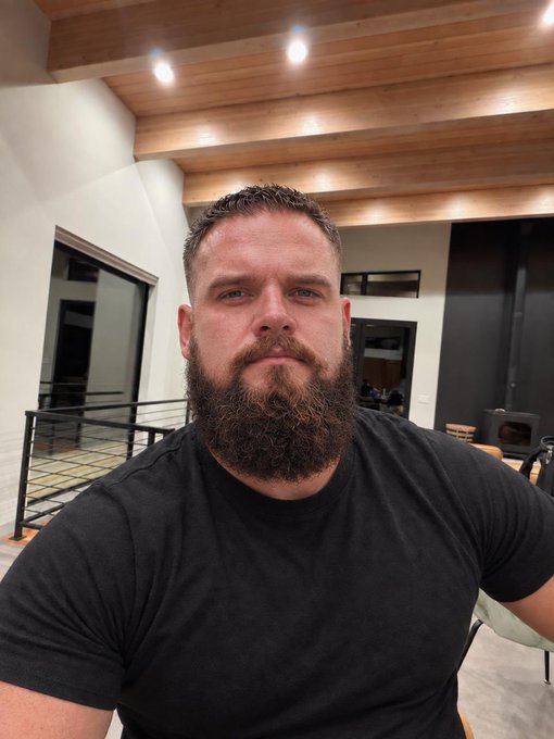A bearded man in a black t-shirt takes a close-up selfie indoors, with his freshly groomed beard on display. The image pairs with a post about a lackluster crypto market and his decision not to trade, showing him sporting a tidy new haircut as he steps back from the markets for the day.