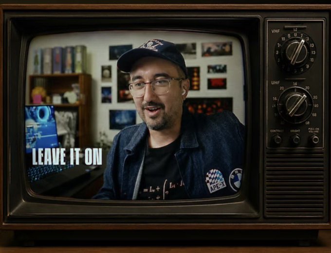 A person wearing glasses and a baseball cap appears on a retro television screen, with the text "LEAVE IT ON" displayed in the lower left corner.