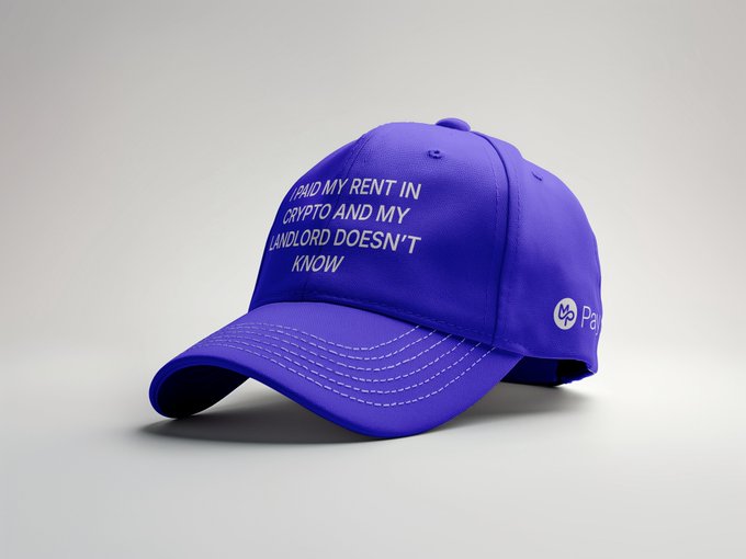 A purple baseball cap with white embroidered text reading "I PAID MY RENT IN CRYPTO AND MY LANDLORD DOESN'T KNOW" alongside a logo.