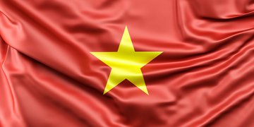 The Vietnamese flag is displayed, representing the country preparing to enforce new crypto regulations that would penalize users trading on unlicensed offshore platforms like Binance, OKX, and Bybit, despite no fully licensed local exchanges existing before the September market launch.