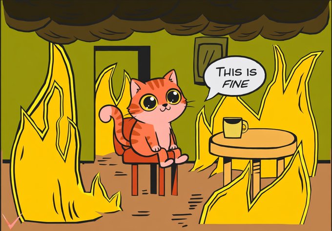 The image features a cartoon cat sitting at a table with a cup of coffee next to it. The cat appears to be looking sad or upset as if it has just experienced an unpleasant event, such as being burned by fire. Above the cat's head, there is a speech bubble that says "This is fine". This adds humor and a touch of whimsy to the scene, making it seem like the cat is talking back at the viewer with its words. The overall atmosphere of the image conveys a sense of sadness or disappointment for the cat while also providing a lighthearted response from the cartoon character.