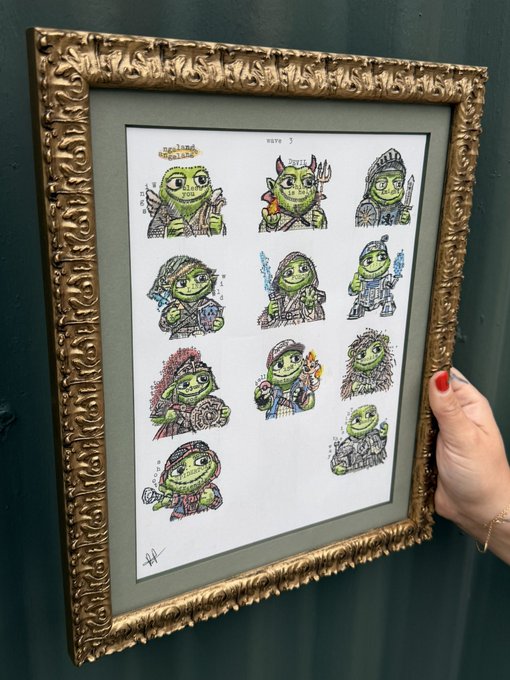 A hand with red nail polish holds up an ornate gold picture frame containing a hand-drawn illustration sheet of various green goblin-like characters.