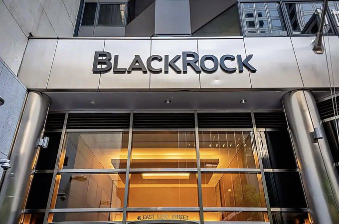 The exterior entrance of a building featuring a metallic sign with the word 'BLACKROCK' in large letters above glass doors, with the address '50 EAST 52ND STREET' partially visible.