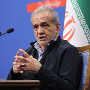 Iranian President Masoud Pezeshkian speaks at a podium with Iranian flags in the background, the image illustrating the post about U.S. Treasury sanctions freezing over $130 million in crypto linked to Iran's financial network.