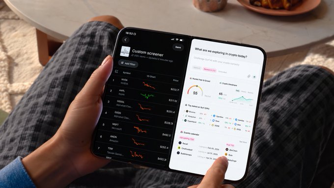 A person holds a Samsung foldable phone displaying a custom screener with a list of top crypto coins including MOODENG, AAPL, COIN, GOOG, MSFT, and AMZN, alongside market analysis screens.