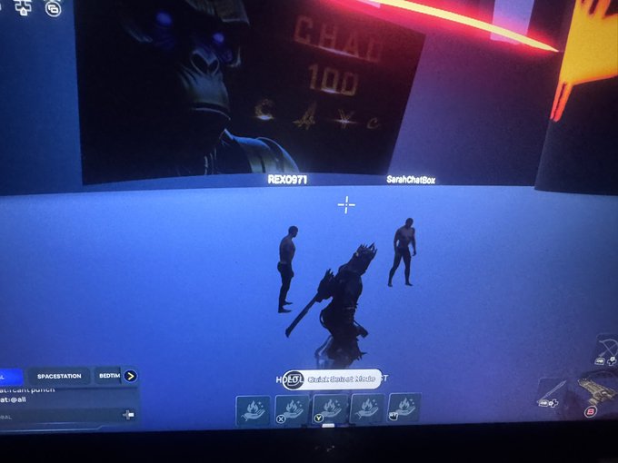 A photograph of a monitor displaying a Fortnite gameplay scene with players REXO971 and SarahChaiBox, showing an in-game HUD with ability icons and a 'CHAD 100' display.