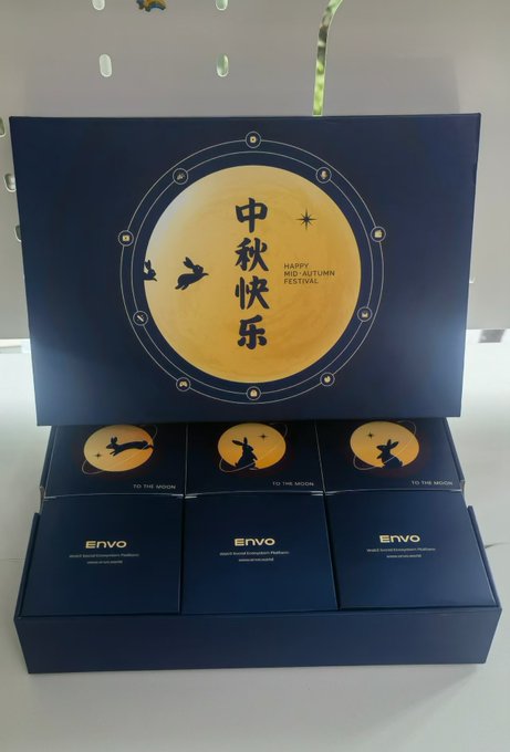 A dark blue Mid-Autumn Festival gift box from ENVO featuring a golden moon with a rabbit silhouette and 'HAPPY MID-AUTUMN FESTIVAL' text, with smaller individual boxes below reading 'TO THE MOON'.